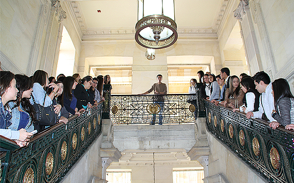 Imagen:En el congreso, sobre unas escaleras, un representante de Atención al Ciudadano está asesorando a un grupo de adultos.
